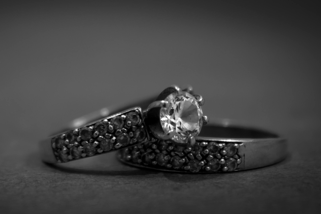 A black and white close-up of a matching set of wedding bands displayed one on top of the other.