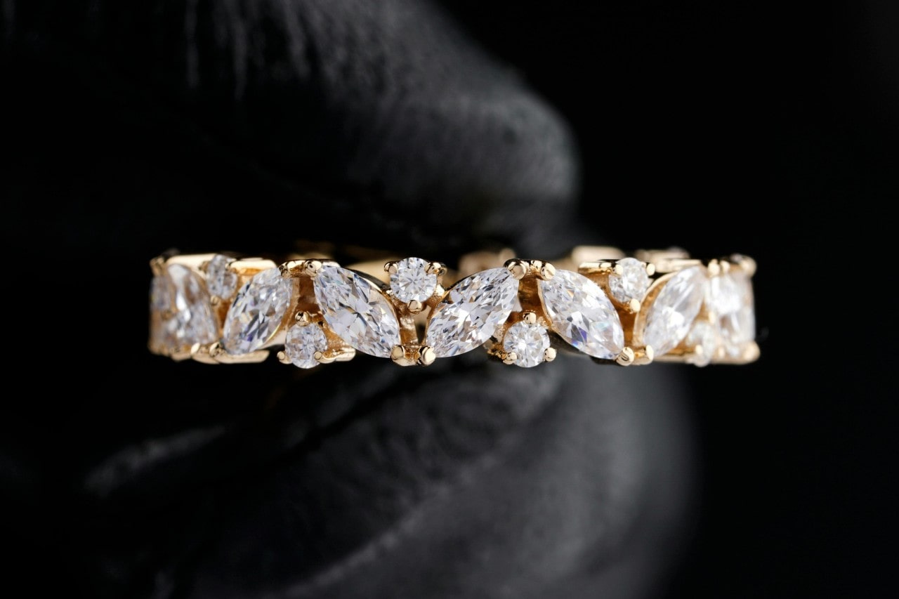 A close-up of a stunning ladies wedding band, adorned with round and marquise cut diamonds.